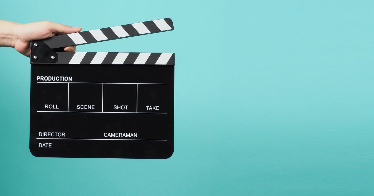A movie scene clapboard on a turquoise background